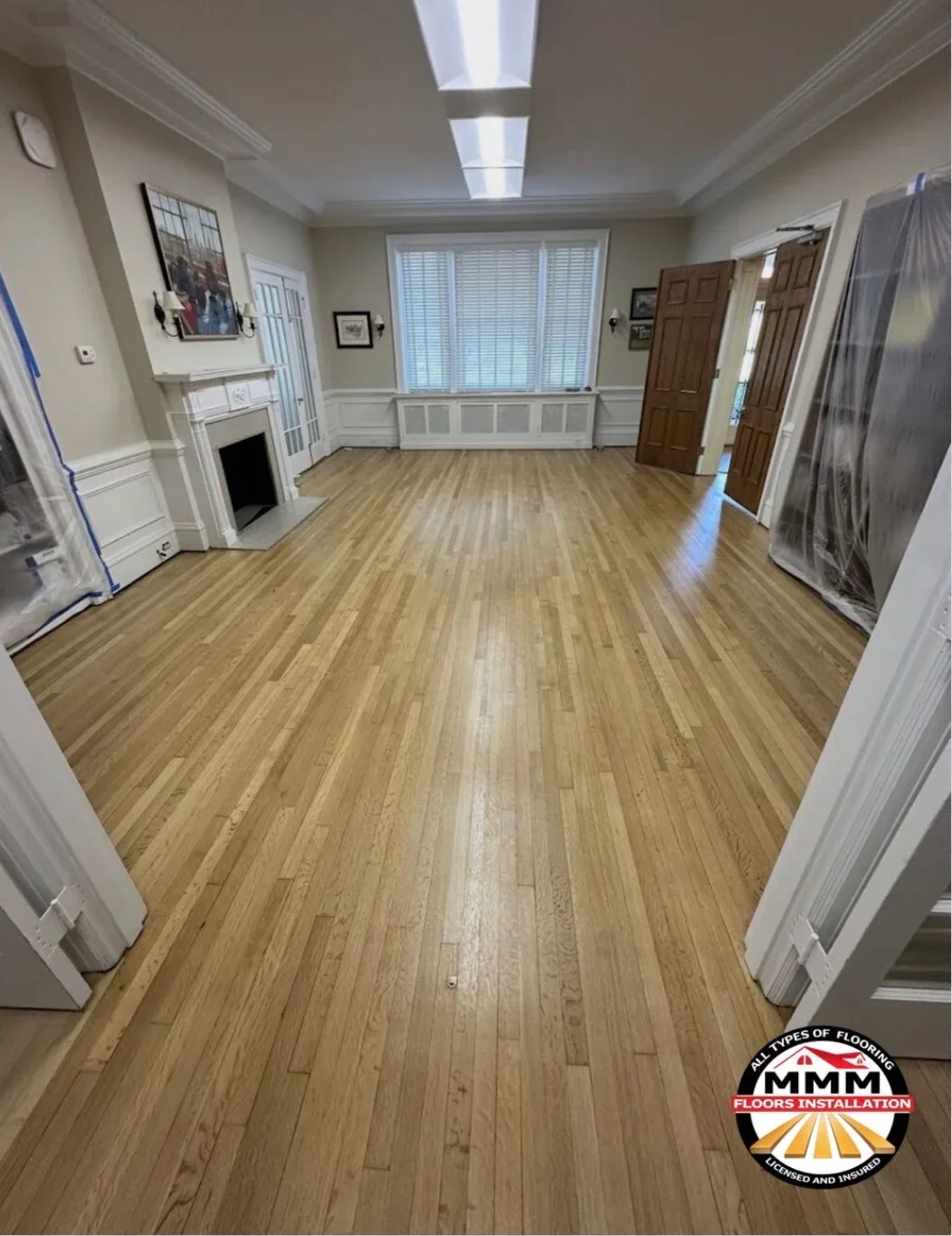 Newly installed hardwood flooring with oak planks and white baseboards in residential room